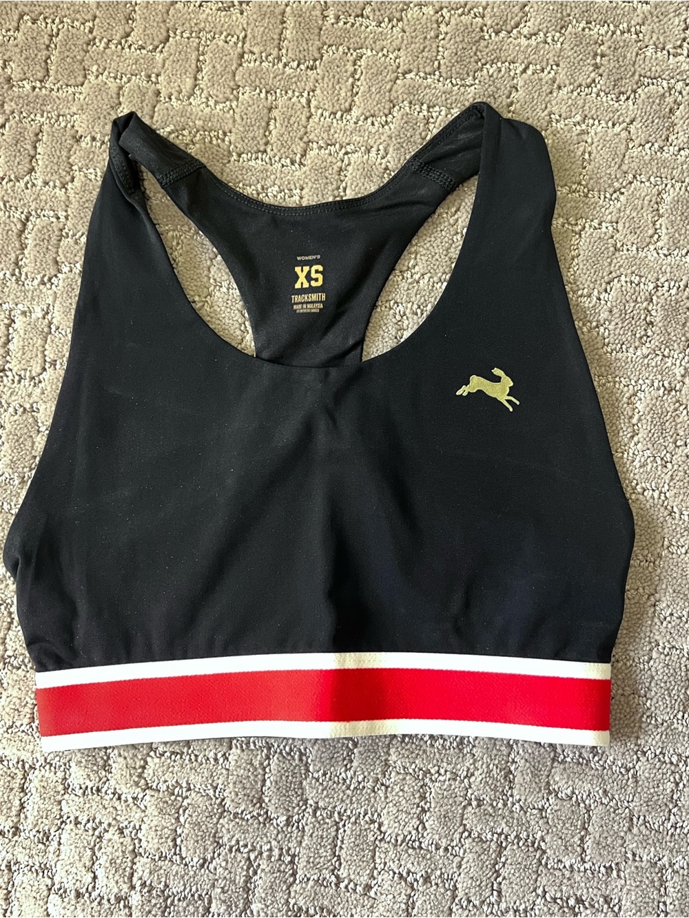 Tracksmith Black Sports Bra with Red and White Striped Band and Gold Logo